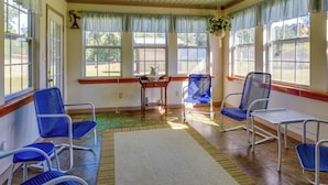 Une pièce avec des chaises bleues, une table et un tapis.