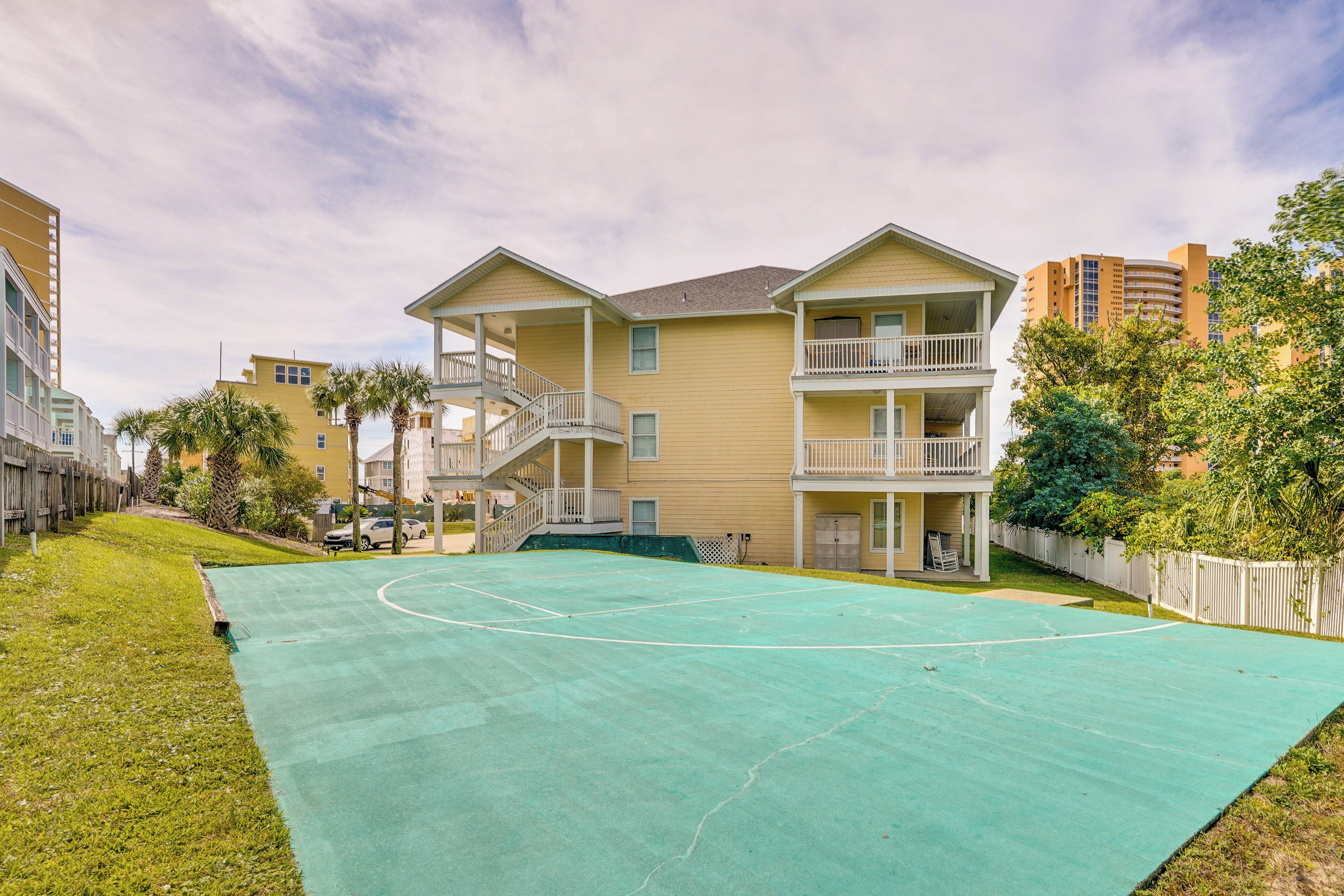 Un edificio residencial con una cancha de baloncesto al frente.