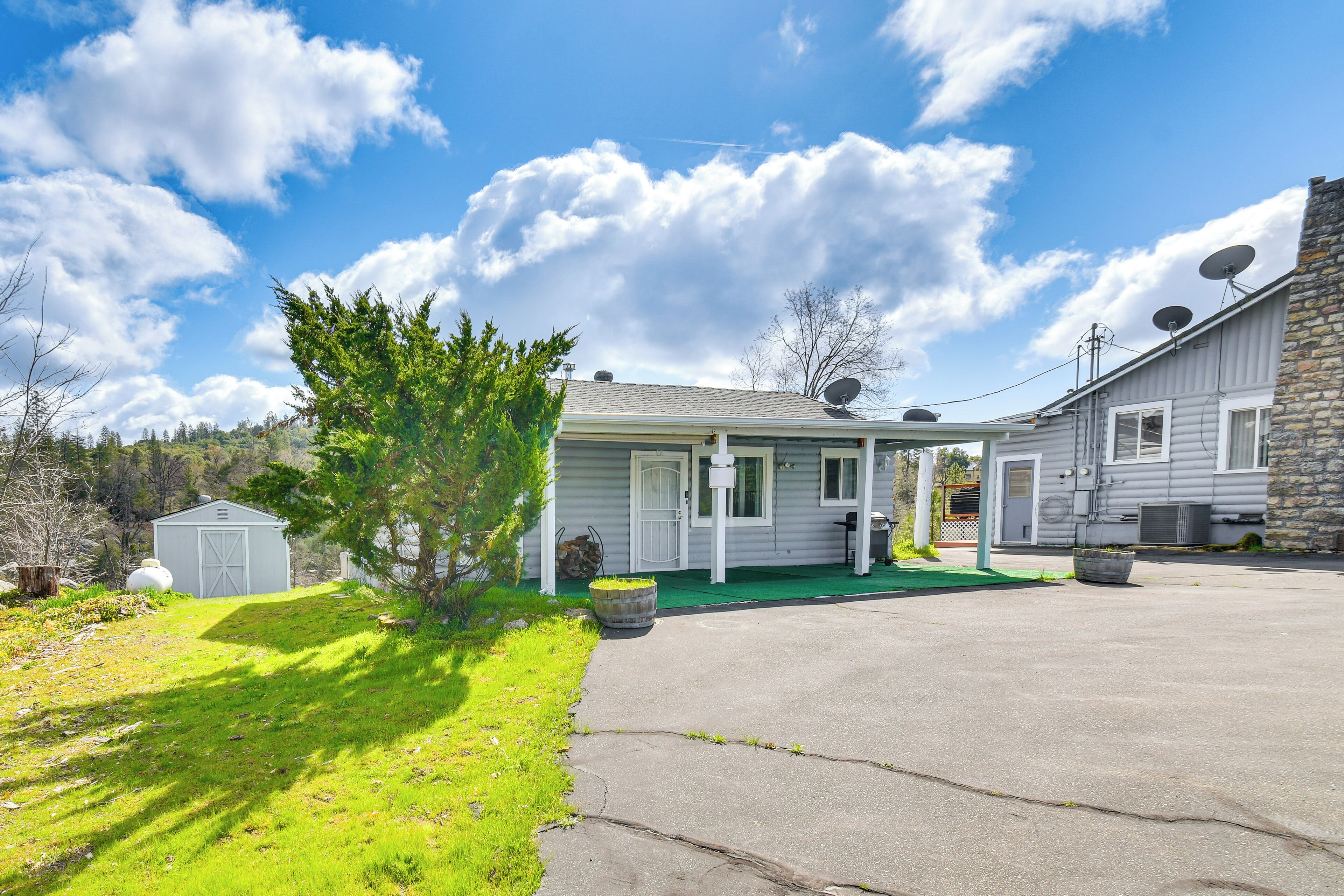 A two-story house with a garage, satellite dishes, and a small shed.