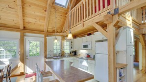 A spacious kitchen with a large island, wooden beams, and a loft area. - Frye Island Family Cabin With Lake & Beach Access! (Raymond)