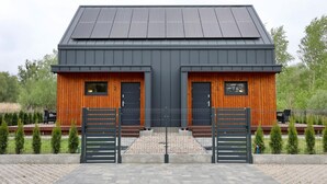 A modern building with two doors and a solar panel roof. - House in Stepnica by Szczecin Lagoon (Stepnica)
