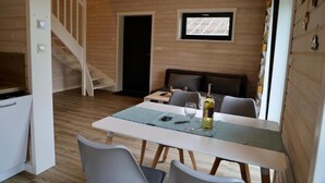 A compact living space with a dining area, a sofa, a television, and a staircase. - House in Stepnica by Szczecin Lagoon (Stepnica)