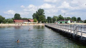 A waterfront area with a pier, buildings, and a beach. - House in Stepnica by Szczecin Lagoon (Stepnica)