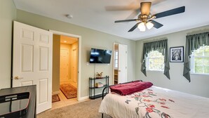 A bedroom with a bed, a television, a ceiling fan, and a door leading to another room. - Quiet Killingworth Rental w/ Deck & Grill! (Killingworth)