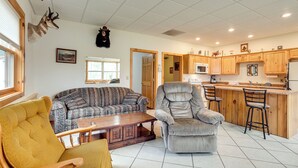 A living room with a sofa, armchair, and a wooden coffee table. - Boat Dock & Fire Pit: Lakefront Monico Home! (Rhinelander)
