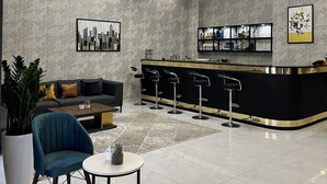 En moderne lobby med barområde, siddepladser og et bykunstværk.