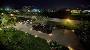 A nighttime outdoor area with a paved walkway, seating, and decorative lighting. - King Studio - One
 (Georgetown)