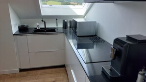 Eine moderne Küche mit Oberlicht, Backofen und Kaffeemaschine.
