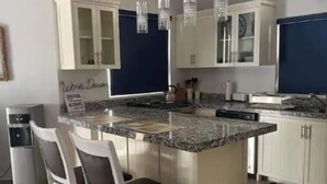A kitchen with a central island, white cabinets, and a blue accent wall.