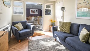 Un salon moderne avec deux canapés, une table basse et une grande fenêtre.