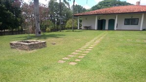 A well-maintained lawn with stepping stones leading to a house with a tiled roof and a green door.
