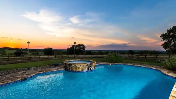 A swimming pool with a hot tub at sunset. - Stunning Fredericksburg Ranch House with Pool and Hot Tub! (Fredericksburg)