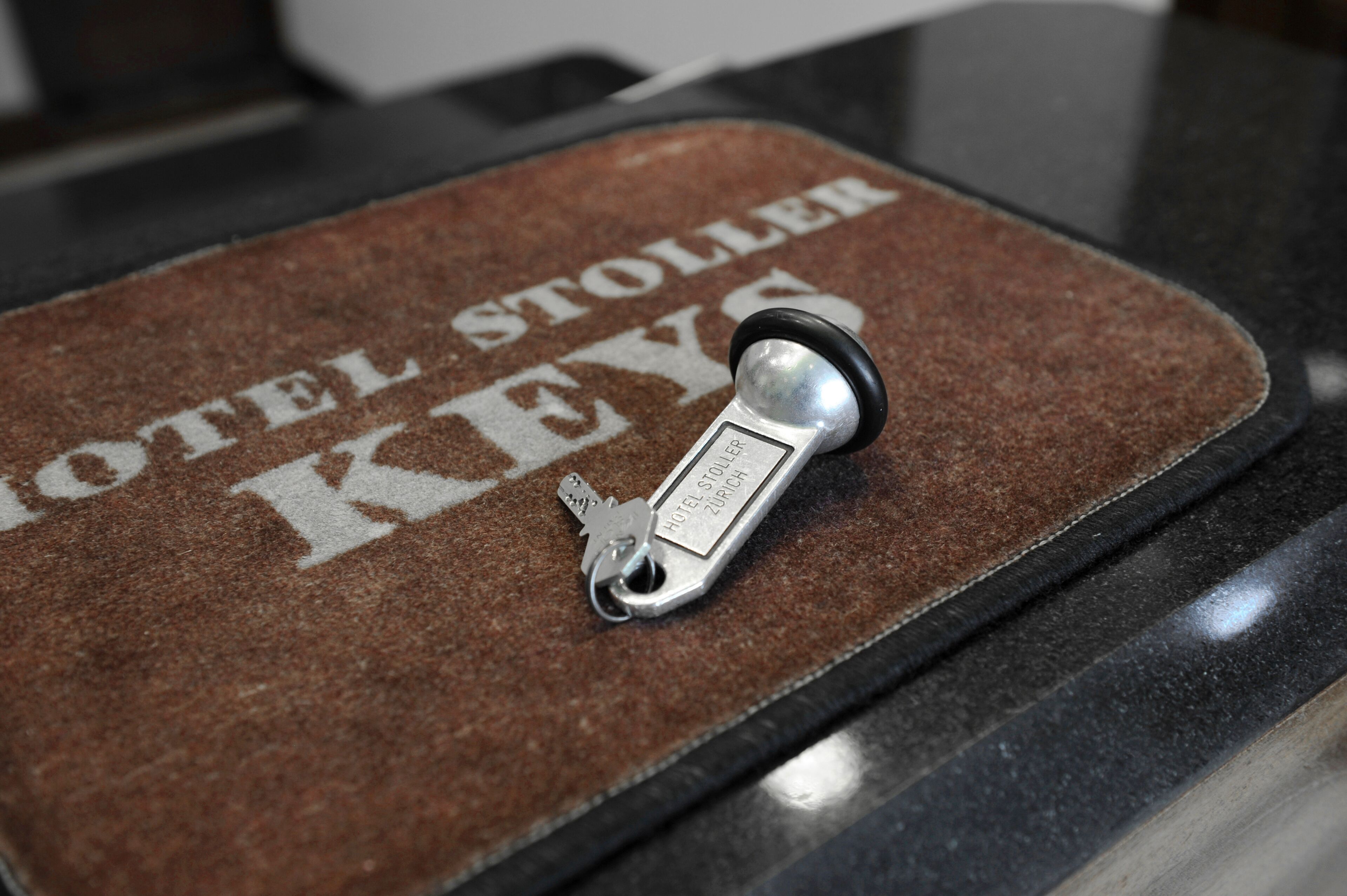 A hotel key holder with a key and a sign that reads "HOTEL STOLER KEYS".