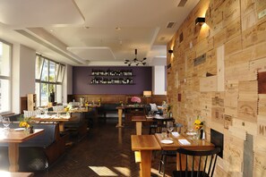 A restaurant with wooden walls, a herringbone floor, and a wine rack on the wall. - Hotel Stoller (Zürich)
