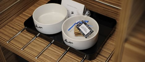 Two white bowls with the brand name "Roller" on a black tray in a wooden interior.