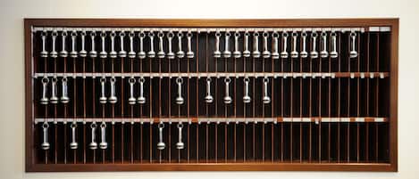A wall-mounted metal rack with multiple hanging metal objects.