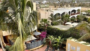 Un complexe hôtelier doté d’une piscine, de palmiers et offrant une vue sur un paysage montagneux.