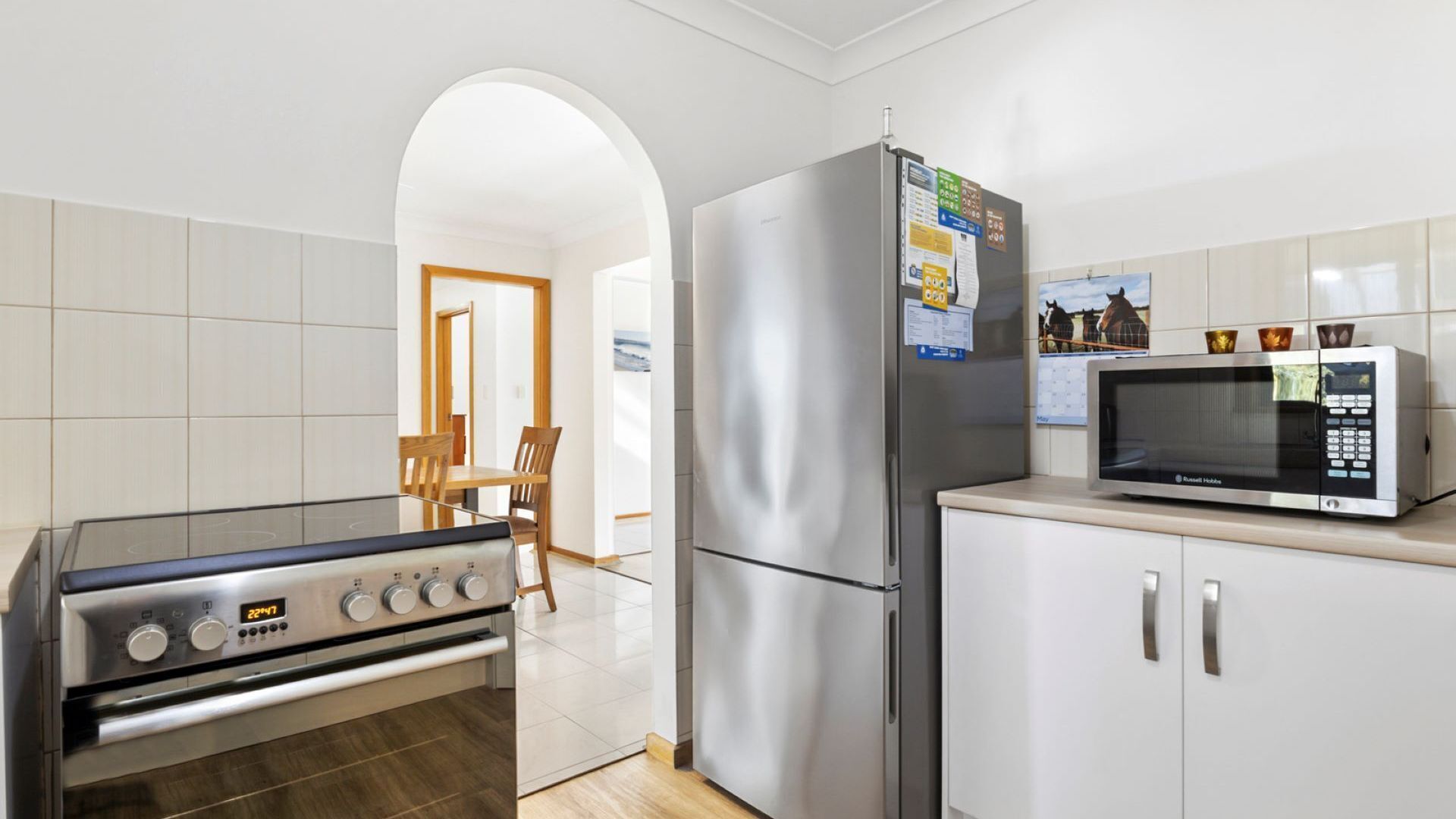 A modern kitchen with a stainless steel stove, refrigerator, and microwave.