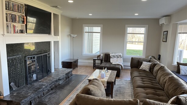 A living room with a fireplace, a large sectional sofa, and a bookshelf. - In ground Pool with unbeatable views, ASV (Otego)