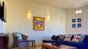 A living room with a sofa, a chair, a coffee table, and a painting on the wall. - 3B Cerritos Beach Condo, Lrg Pool, Baja Sur (El Pescadero)
