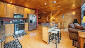 Eine Küche mit Holzschränken, einer Mikrowelle, einem Kühlschrank und einem Herd.