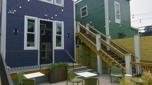 A building with a blue exterior, a wooden staircase, and outdoor seating with chairs and tables. - Double Pour @Tartan House - 2 Suites in 1 Sleep 10 (Louisville)