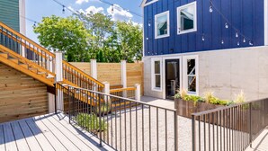 A modern building with a blue exterior, a wooden staircase, and a deck area with railings. - Rickhouse Loft @Tartan House - Studio+Loft Sleep 6 (Louisville)
