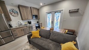 Una cocina moderna con electrodomésticos de acero inoxidable, armarios de madera y un comedor con una mesa y sillas de madera.