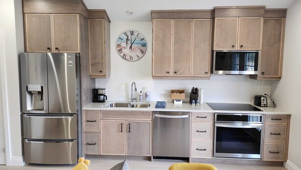 Una cocina moderna con electrodomésticos de acero inoxidable, armarios de madera y una isla central.