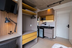 A compact kitchen with built-in appliances, a microwave, and a coffee machine. - Vossa Bossa Chez Frei (São Paulo)