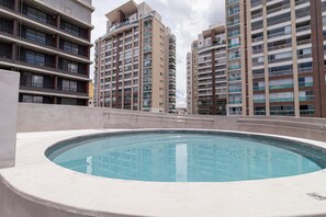 A rooftop swimming pool with a view of high-rise residential buildings. - Vossa Bossa Chez Frei (São Paulo)