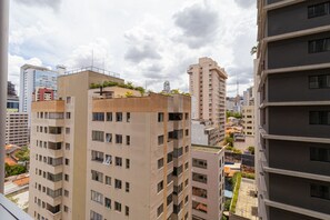 A high-rise residential building with multiple balconies, a rooftop garden, and a view of surrounding high-rise buildings. - Vossa Bossa Chez Frei (São Paulo)