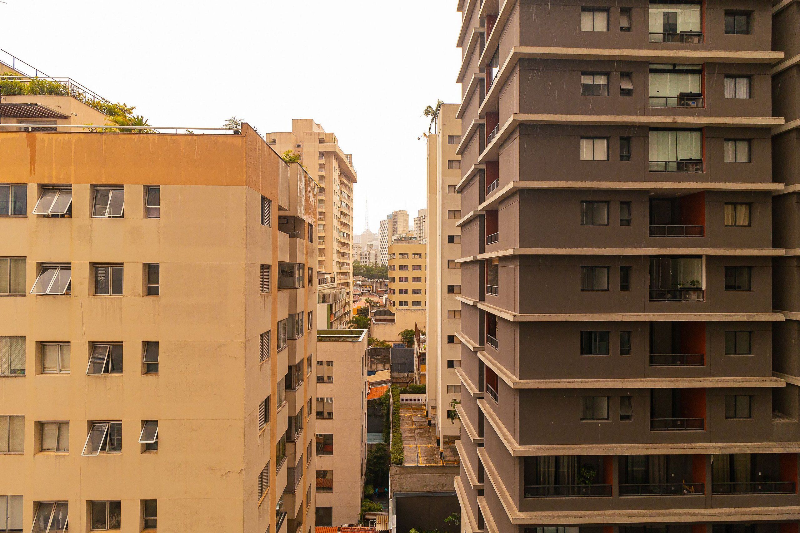 Un edificio residencial de varios pisos con balcones y ventanas grandes.