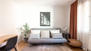 A modern bedroom with a bed, a desk, a potted plant, and a framed picture on the wall. - 2ndhomes Modern & Cozy 2BR Apt w Balcony (Helsinki)