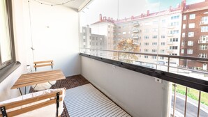 A balcony with a table and chairs, a view of buildings, and a railing. - 2ndhomes Modern & Cozy 2BR Apt w Balcony (Helsinki)