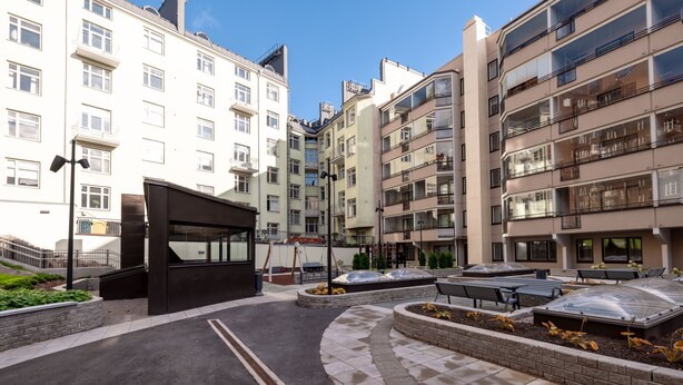 A modern apartment complex with multiple balconies, a central courtyard with benches, and a small garden area. - 2ndhomes Modern & Cozy 2BR Apt w Balcony (Helsinki)