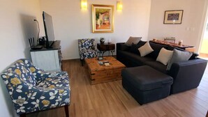 A living room with a sofa, armchair, coffee table, and a small side table.