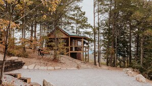 Una baita rustica con una veranda in legno e un vialetto in pietra che conduce all'ingresso.