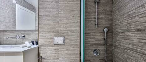 A modern bathroom with a shower, a sink, and a mirror.