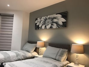 2 habitaciones, escritorio y tabla de planchar con plancha