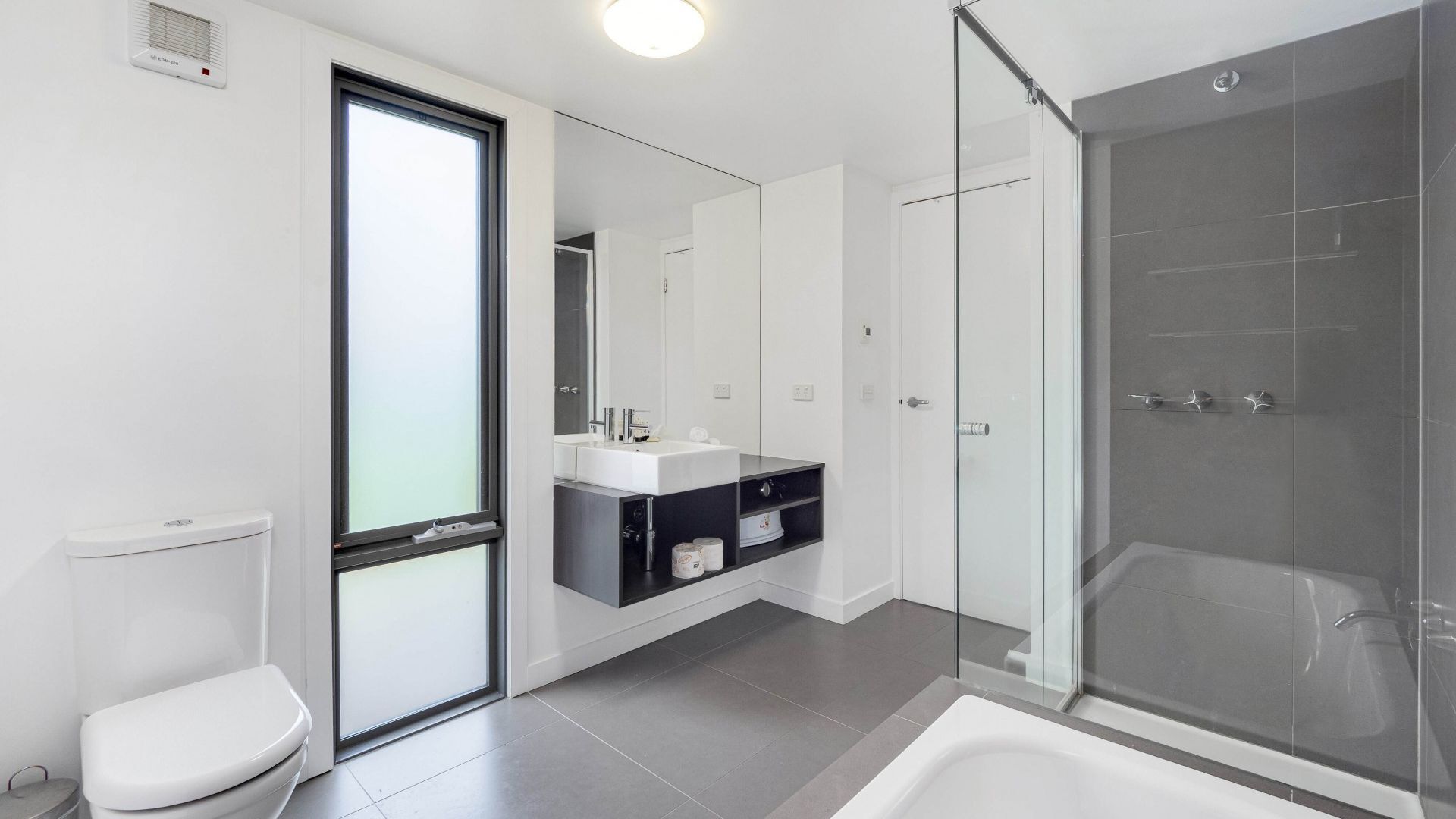 Une salle de bain moderne équipée de toilettes, d’un lavabo et d’une douche.