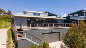 A modern two-story house with a balcony, a garage, and a staircase.