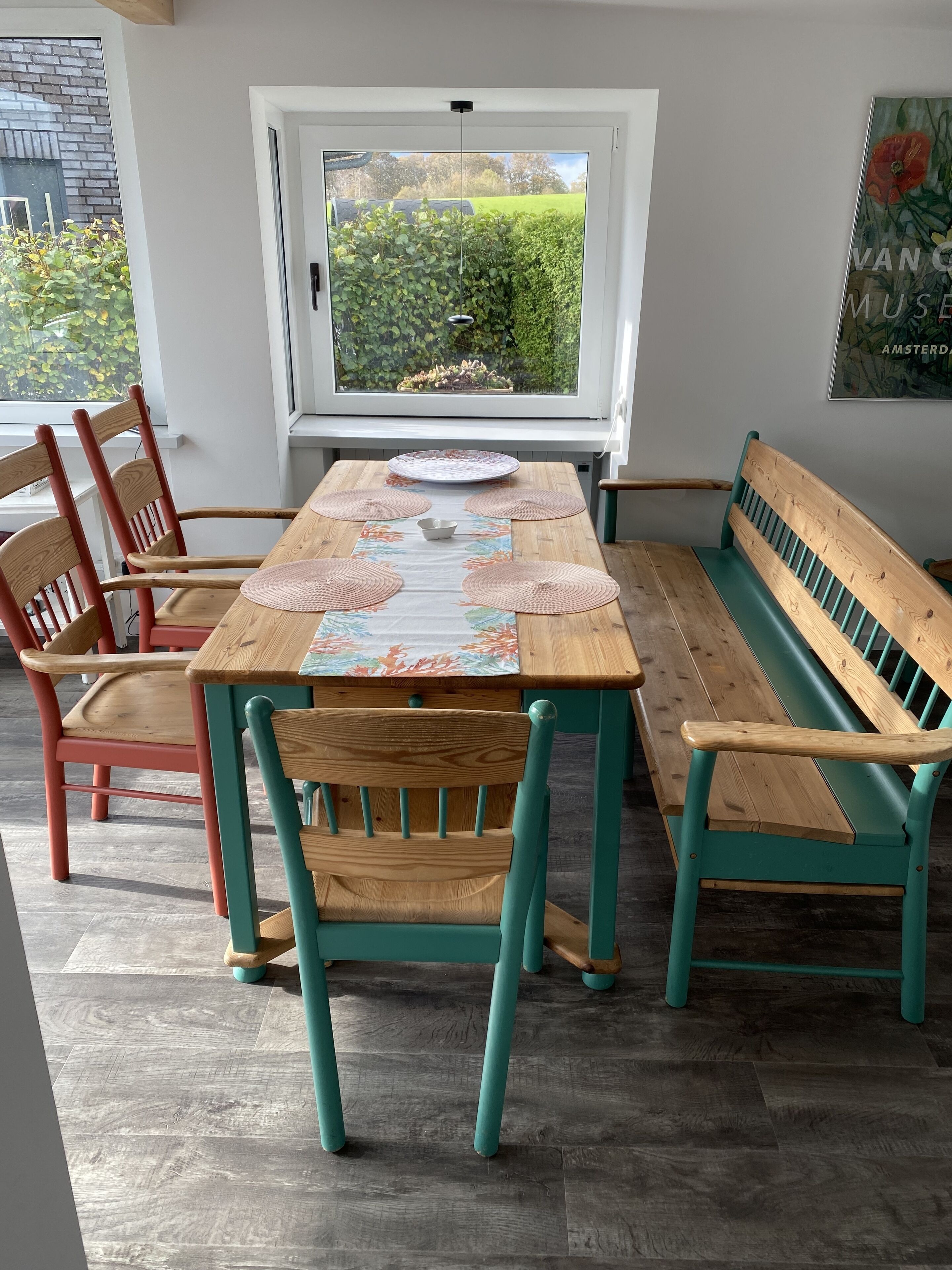 A dining area with a wooden table, four chairs, and a bench.