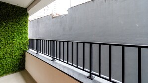 Uma varanda com parede verde e parede de concreto cinzento.