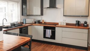 A compact kitchen with a built-in oven, microwave, and a coffee maker on the countertop. - The Pheasantry (Bridlington)