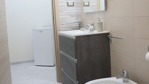 Un baño moderno con un bidé, un lavabo y un espejo.