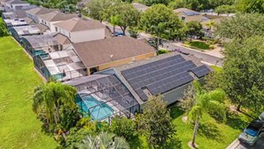 A residential area with houses, a swimming pool, and solar panels on the roof. - Home in Davenport close to Parks w/Pool (Davenport)