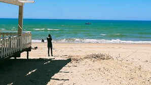 Una playa con un muelle de madera y vista al océano.