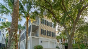 A two-story house with a garage, surrounded by palm trees and a well-maintained lawn. - Beautiful Traditional Home with Private Pool! 5 BR 4 BA (Isle of Palms)