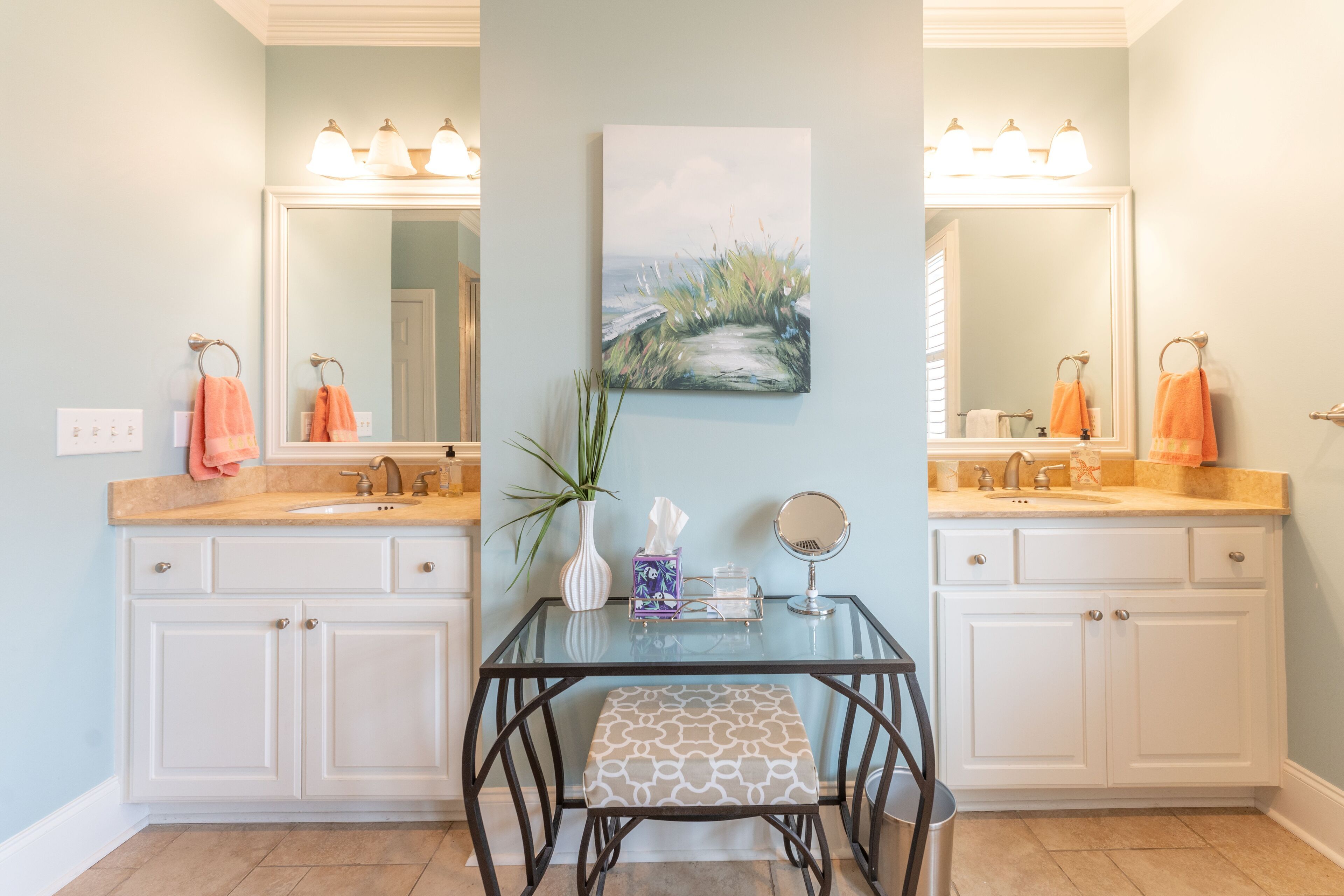 Un baño con dos lavamanos, un espejo y un cuadro en la pared.